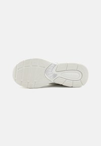 White athletic shoe outsole featuring a textured rubber sole with patterned grooves for traction and support. Brand logo visible in the design.