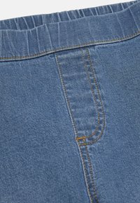 Jeans med resår i midjan, blå färg, med vertikala sömnadsdetaljer och en slät yta.