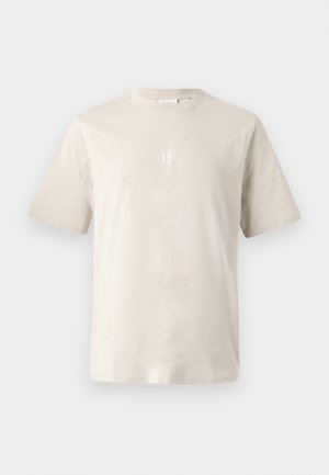 Beige cotton t-shirt with short sleeves, crew neck, and a centered white "II" graphic on the chest. Smooth texture, minimalist design.