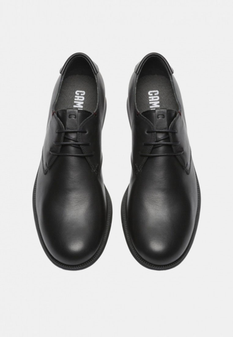 Schwarze Lederschuhe mit glatter Oberfläche, runde Zehenform und Schnürdesign. Minimale Akzente und strukturierte schwarze Sohle.