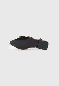 Black high-heeled shoe with a pointed toe and a textured bottom. Features decorative hardware accents on the upper side.