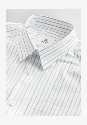 Valge särk, millel on õhukesed hallid vertikaalsed triibud, nupuga krae, üks rinnaehe ja brändi silt, mis on õmmeldud krae sisse.