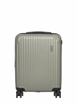 Srebrna walizka z twardą obudową z pionowymi żłobieniami, czterema podwójnymi obrotowymi kółkami i górnym uchwytem do przenoszenia.