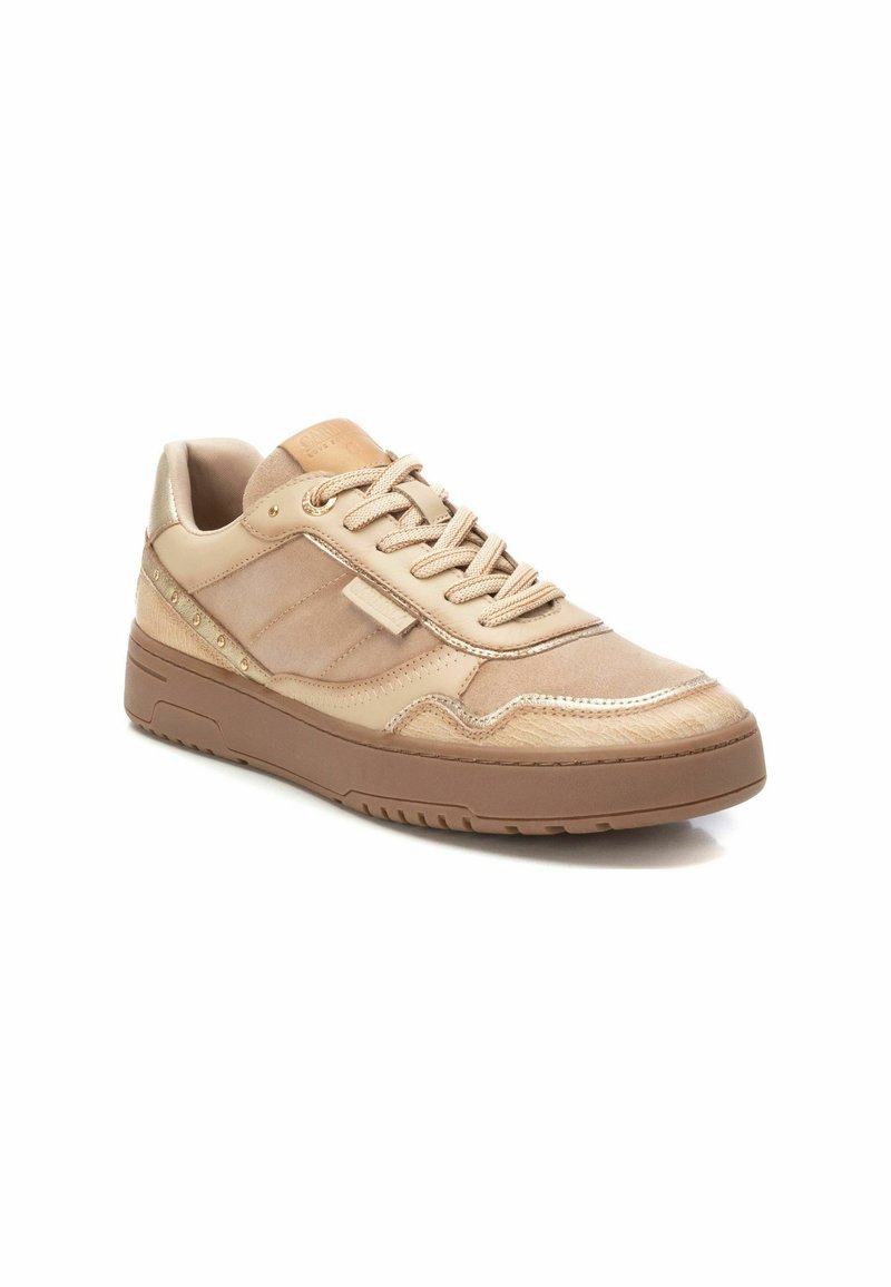 Zapatilla beige con parte superior de cuero liso, acentos texturizados, cordones planos, cuello acolchado y suela de goma resistente con un dibujo en la banda de rodadura.