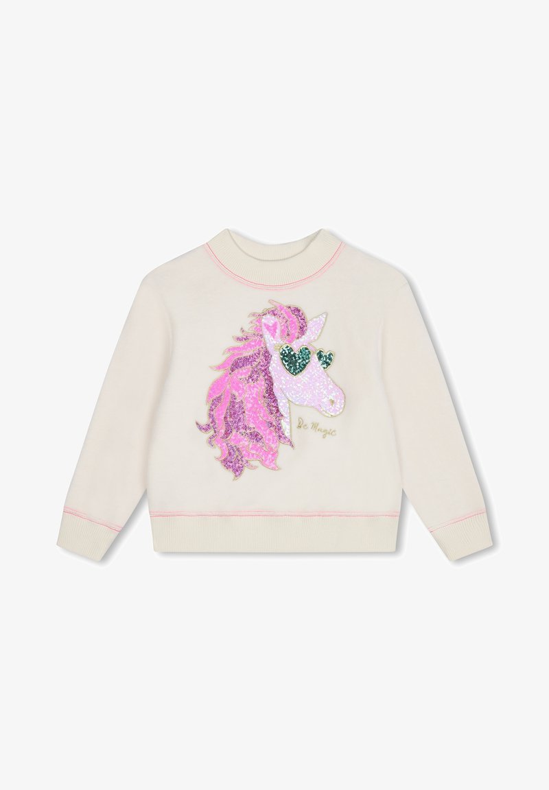 Sweat-shirt crème à manches longues avec une licorne à crinière rose portant des lunettes vertes en forme de cœur et le texte "Be Magic" sur le devant.