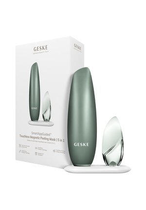 Appareil de masque peeling GESKE allongé vert et applicateur magnétique transparent sur un plateau blanc à côté de l'emballage du produit avec branding et caractéristiques.