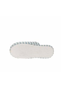 Pantufla a rayas azul y blanca, con una suela de goma blanca texturizada y acolchada, que presenta un logotipo en la parte inferior. Diseño simple y ligero.