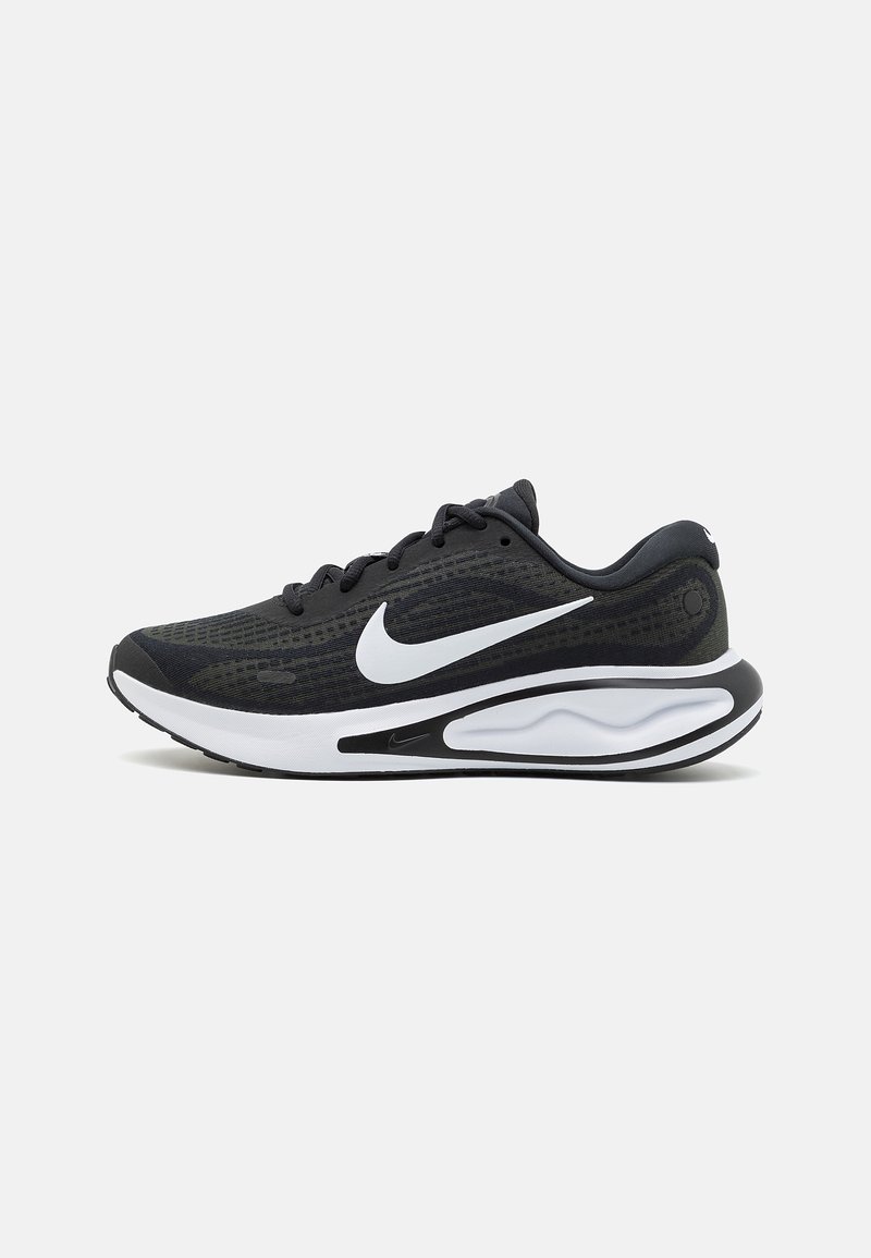 Chaussure de running Nike noire et blanche avec empeigne en mesh, logo Swoosh blanc, semelle amortie et lacets noirs sur fond blanc.