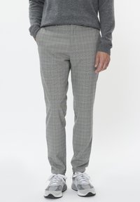 Pantalones de cuadros gris con corte slim, que presentan un sutil patrón de cuadros con acentos en amarillo y azul. Fabricados con una tela suave.