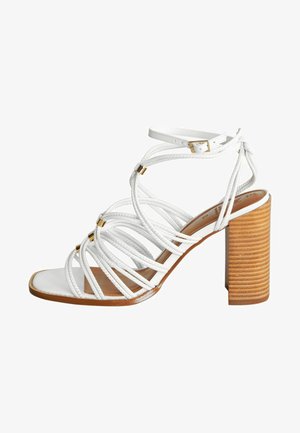 Sandali con tacco bianco, con cinturini intrecciati, design aperto sulla punta, cinturino alla caviglia regolabile e tacco a blocco in legno texture. Presenti dettagli in oro.