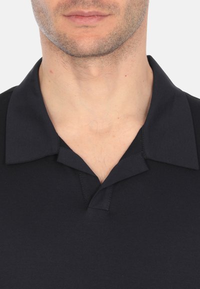 Camisa polo azul marino con cuello clásico, mangas cortas y una textura suave de algodón. Presenta una tapeta de tres botones en el cuello.