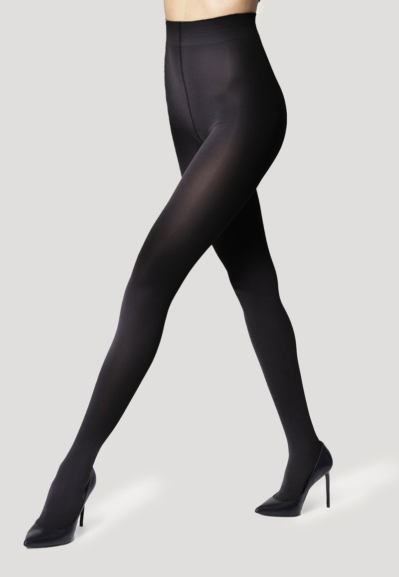 Collant neri opachi con una vita alta, texture liscia e design aderente, abbinati a scarpe nere con tacco alto.