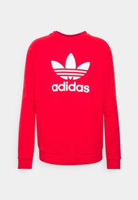 Sudadera roja de algodón, con mangas largas y un cuello redondo. Presenta un gran logo blanco de Adidas con tres franjas y un diseño de hoja.