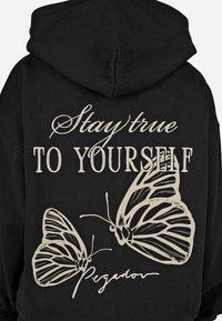 Fekete kapucnis pulcsi fehér szöveggel: "Maradj hű önmagadhoz" és két kontúros pillangó mintával, tintás részletezéssel és texturált felülettel.