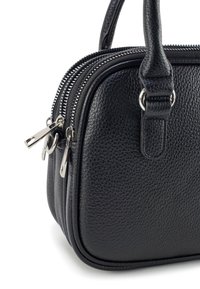 Zwarte gestructureerde leren handtas met dubbele ritscompartimenten en korte handvatten, van dichtbij getoond op een witte achtergrond.