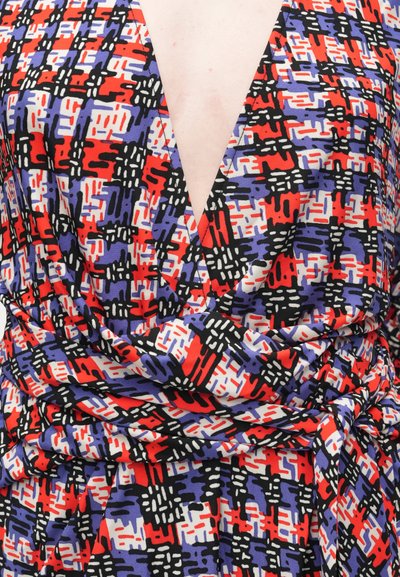 Vestido envolvente em padrões geométricos vibrantes e multicoloridos. Apresenta um decote em V profundo, nas cores preto, vermelho, branco e roxo, feito de um tecido suave com textura.