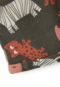 Tissu avec un fond gris foncé et des motifs animaliers colorés, y compris des chats à taches rouges et des zèbres à rayures blanches, avec une finition texturée.
