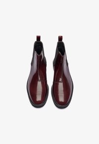 Botine din piele burgund cu un finisaj lucios, panouri laterale elastice și cârlige de tragere, având o talpă din cauciuc texturat negru.