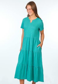 Türkisfarbenes, gestuftes Kleid mit kurzen Ärmeln, V-Ausschnitt und zwei Seitentaschen. Hergestellt aus leichtem Stoff mit subtiler Textur und fließender Silhouette.