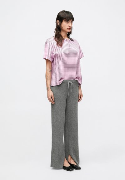 Pruhovaná ružovo-biela krátky rukáv košeľa s golierom, skombinovaná so sivými rebrovanými širokými nohavicami s rozparkami a čiernymi balerínami.