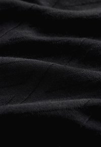 Zwart gestructureerde stof met een zachte oppervlakte, voorzien van subtiele diagonale lijnen. Materiaal oogt lichtgewicht en licht glanzend.