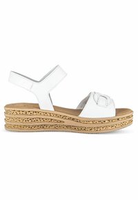 Sandale en cuir blanc avec une plateforme en liège, présentant un design à lanières croisées et un bout arrondi. Semelle texturée pour l'adhérence.