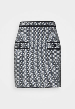 Kort nederdel i et marineblåt og hvidt helhedsmønster med logo. Har to forlommer med sort kant og knapdetaljer. Fremstillet af vævet stof.