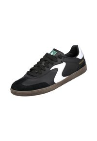 Zapatilla negra y blanca hecha de cuero suave y ante, con una suela de goma gruesa, cordones negros y un logo verde en la lengüeta.