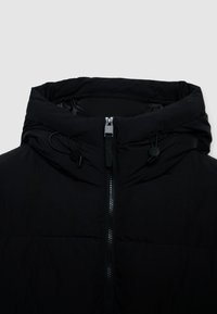 Giacca nera isolata con colletto alto, zip frontale, cordini regolabili e una texture esterna liscia.