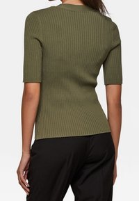 Top de punto acanalado verde oliva con mangas cortas y un diseño ajustado, que presenta un escote redondo y una superficie texturizada.