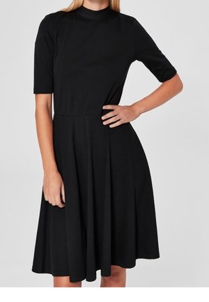 Vestido negro con cuello alto, mangas cortas y falda acampanada. Tela lisa con una silueta clásica y costuras mínimas.