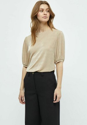 Gold metallic short-sleeve top with a round neck, gathered puff sleeves, paired with tailored black high-waisted trousers.