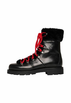 Botte d'hiver en cuir noir avec des lacets rouges, bord en fourrure noire et semelle robuste, montrée de côté sur un fond blanc.