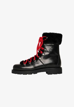 Botas de invierno de cuero negro con cordones rojos, puño de pelo negro y suela resistente, mostradas de perfil sobre un fondo blanco.