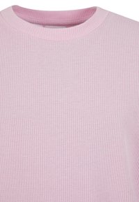 Lys rosa ribbestrikket genser med rund hals; stoffet har et teksturert mønster med subtile variasjoner i nyanse.