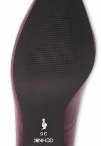 Burgundowa podeszwa buta o gładkiej fakturze z poziomymi rowkami. Rozmiar 36 oznaczony na pięcie na biało.