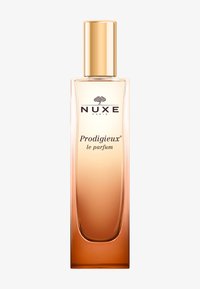 NUXE Prodigieux perfum w wysokiej, przezroczystej butelce ze gradientowym bursztynowym kolorem i złotą zakrętką. Zawiera nadrukowane logo.