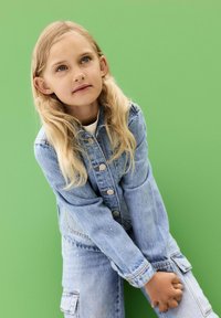 Jeansjacka i ljusblå färg, knäppning fram och utsmyckade detaljer. Bärs med matchande jeansbyxor; slät yta, avslappnad passform.