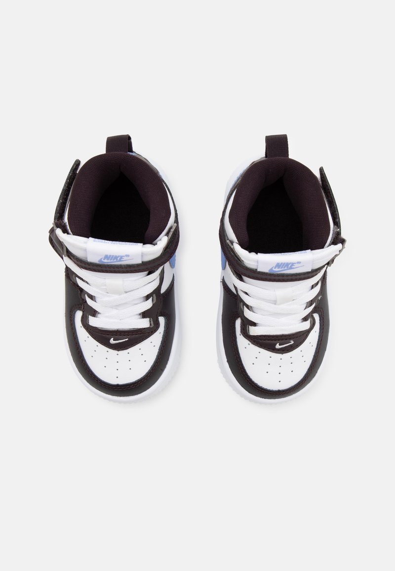 Baskets Nike en noir et blanc avec des accents bleus, extérieur en cuir, bout rond, col rembourré, lanière ajustable et semelle en caoutchouc texturée.