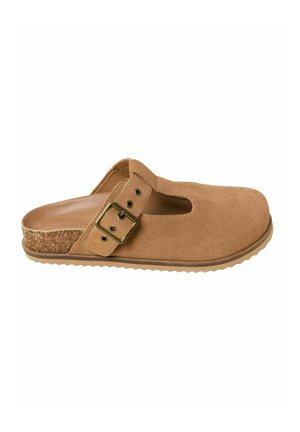 Beżowy zamszowy but wsuwany z okrągłym noskiem, wycięciami dekoracyjnymi, regulowanym paskiem z klamrą, korkowym akcentem na pięcie oraz teksturowaną gumową podeszwą.