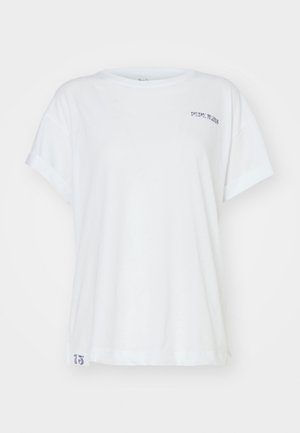 Baltas kokvilnas T-krekls ar sarullētām piedurknēm un apaļu kakla izgriezumu, ar mazu pelēku drukātu logo priekšpusē un numurisku detaļu apakšmalā.