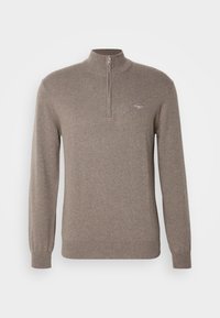 Pull en maille marron à manches longues avec col à fermeture éclair au quart et petit emblème brodé sur la poitrine gauche.