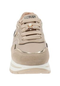 Sneaker beige con suola spessa, lacci in tessuto e un'elegante decorazione a forma di ape con perle e cristalli sui lacci.