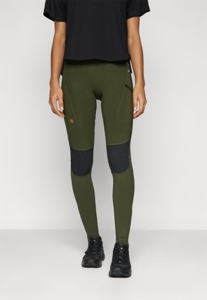 Olive green leggings with black knee patches, fitted design, and zip pocket. Made of stretchable material. Worn with a black cropped top and black shoes.