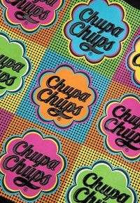 Kolorowa tkanina z powtarzającymi się logo w kształcie kwiatów w kolorze różowym, niebieskim, zielonym i pomarańczowym, z napisem "Chupa Chups" na czarnym tle, na kropeczkowanym tle.