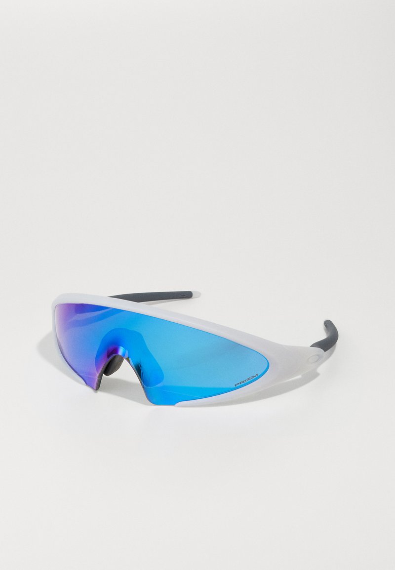 Sportsolglasögon med en genomskinlig vit ram, reflekterande blå linser och svarta detaljer. Aerodynamisk design med en böjd form.