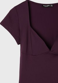 Robe courte manches courtes violet foncé avec encolure en V, buste cintré et étiquette de la marque Stradivarius à l’intérieur du col.
