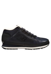 Navy blue high-top sneaker made of leather and mesh, featuring a white fleece lining, black laces, and a textured rubber sole.