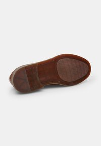 Talpa de pantof din piele maro cu o textură netedă, vârf rotund și un model de profil pentru aderență. Include un toc în contrast și detalii cusute.