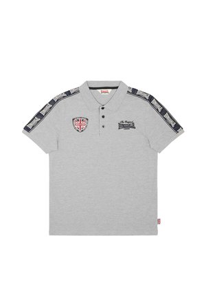 Vaaleanharmaa poolopaita mustilla napeilla, Lonsdale-logo rinnassa ja hihoissa sekä Britannian lipun merkki vasemmassa ylälaidassa.